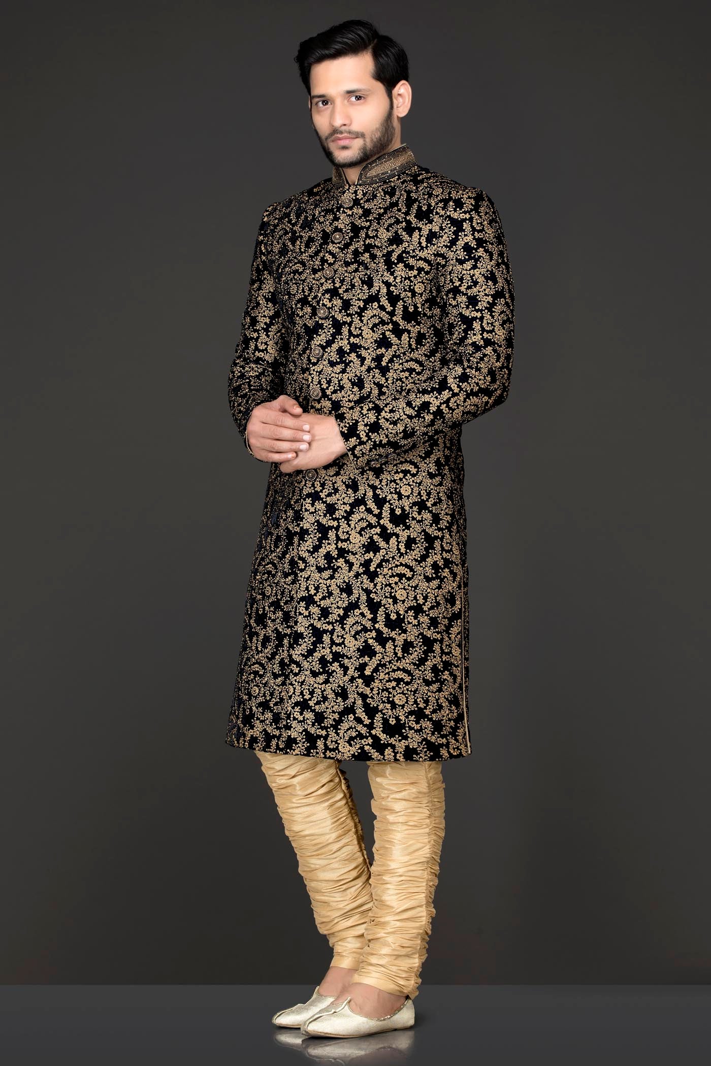 Navy Blue Velvet Sherwani Covered With Gold Zari Embroidery Paired With Gold Chudidar