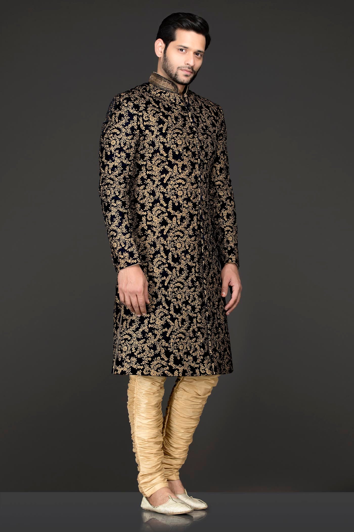 Navy Blue Velvet Sherwani Covered With Gold Zari Embroidery Paired With Gold Chudidar