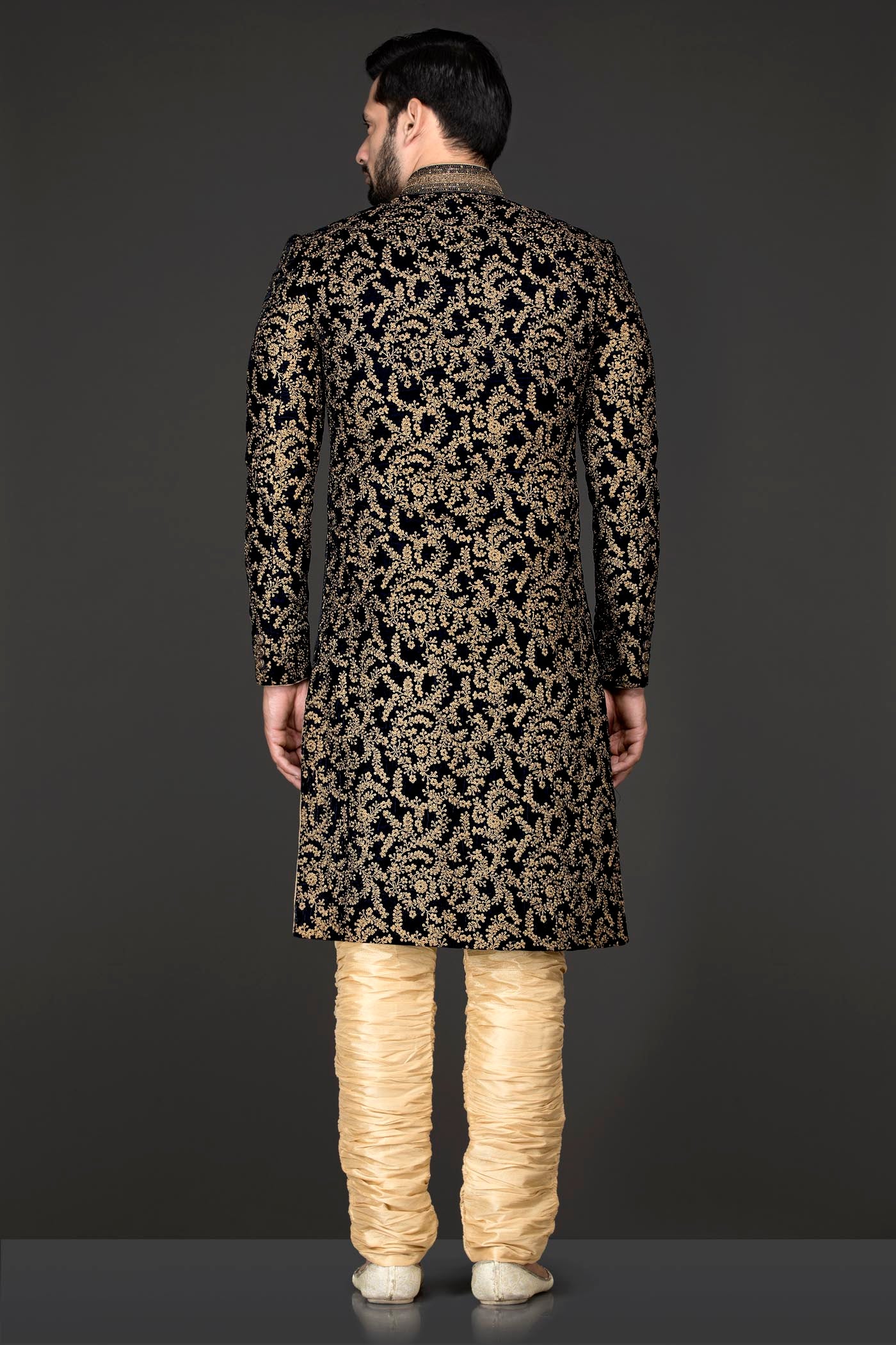 Navy Blue Velvet Sherwani Covered With Gold Zari Embroidery Paired With Gold Chudidar