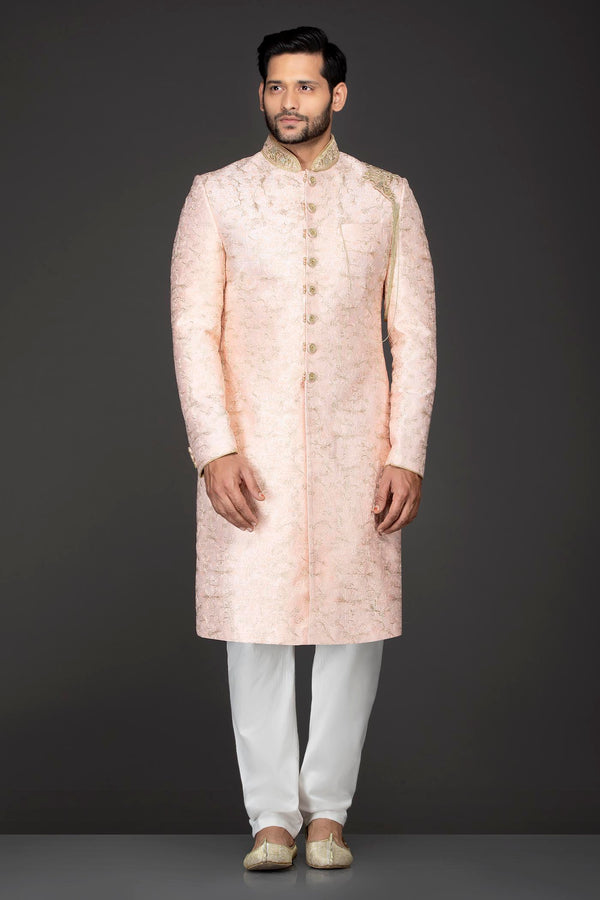 Peach Silk Sherwani With Embroidery On The Collar And Shoulder Brooch With Hanging Tassels Paired With White Trousers
