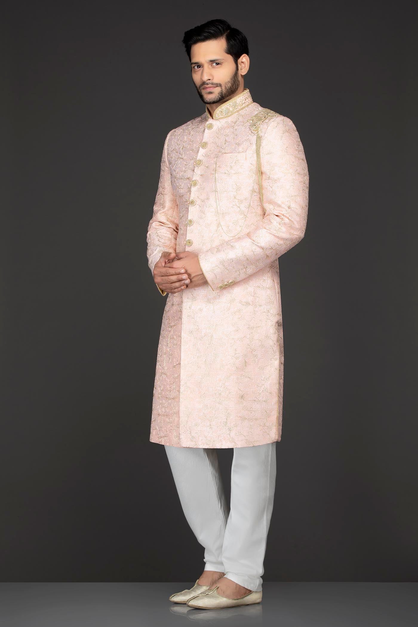 Peach Silk Sherwani With Embroidery On The Collar And Shoulder Brooch With Hanging Tassels Paired With White Trousers