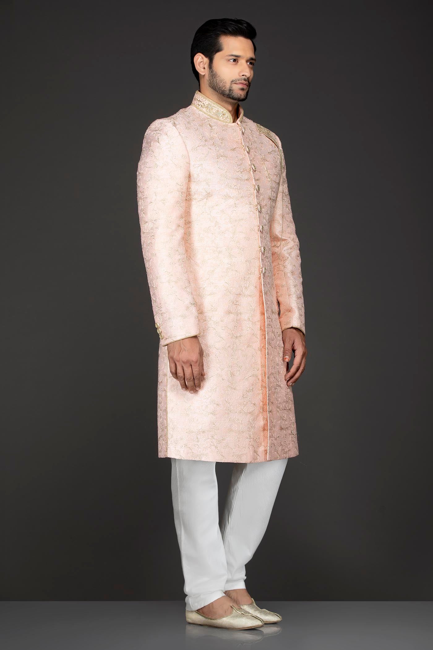 Peach Silk Sherwani With Embroidery On The Collar And Shoulder Brooch With Hanging Tassels Paired With White Trousers